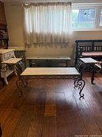 Front view of wrought iron and wood slat bench