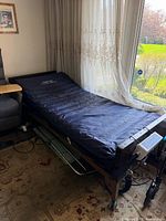 Full view of bed with navy mattress and pump visible