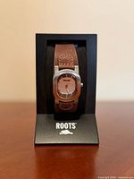 Front view of Roots wristwatch on display stand