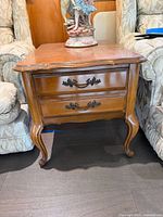 Front and side view of the solid wood French Provincial end table between armchairs