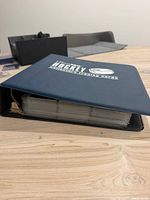 Closed navy binder showing hockey logo and thickness of pages