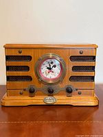 Front view showing wood cabinet, Mickey Mouse clock, knobs, speaker grilles