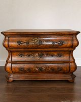 Full front view of bombe dresser showing three drawers and overall finish