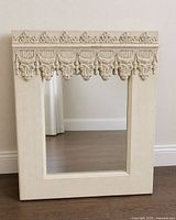 Full view of rectangular mirror leaning against wall