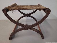 Side view showing cast iron X-frame, wood stretchers, woven rush seat