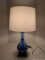 Full view of lit lamp with shade attached