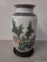 Front view of vase on stand showing landscape scene
