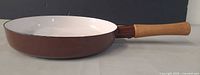 Side view showing brown exterior and wooden handle
