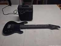 Degas EDG-10 guitar and Squier SP-10 amplifier on table