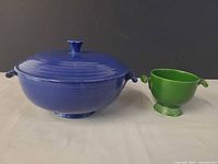 Blue covered bowl and green sugar bowl side by side