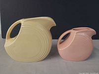 Yellow and pink Fiesta disc pitchers side by side front view