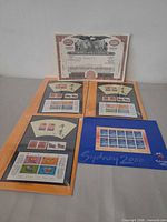 Overview of three Year of the Ox sheetlets in orange folders, Sydney 2000 sheet in blue folder, and one Pan Am certificate