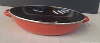 Side view showing red exterior, black interior, and both handles