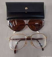 Both eyewear pairs with black protective case visible