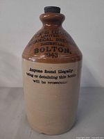 Full view of two-tone stoneware jug with cap, transfer markings visible