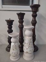 Group view of all five candle holders showing materials and relative sizes