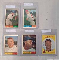 Front view of all five Topps baseball cards in protective sleeves