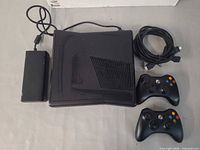 Top view of Xbox 360 console with power supply, HDMI cable, two controllers