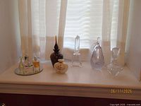 All nine perfume bottles displayed on windowsill