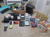 Full lot overview showing electronics, calculators, shredder, cables, writing supplies