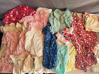 Overview of entire lot of vintage baby clothes laid out on table