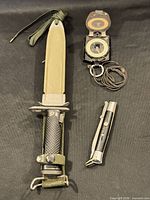 Full lot view showing bayonet in scabbard, compass, folding tool