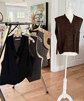 Overall view of four vests on rack and one on mannequin