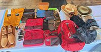 Overview of entire lot showing backpack, hats, binoculars, shoe trees, packing cubes and pouches