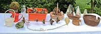 Full lot overview on table showing baskets, pinecones, ceramics, watering can, topiary