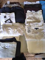 Folded stacks of assorted women’s tops, visible tags and size labels