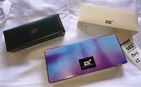 Three branded pen boxes: Montblanc iridescent, Montblanc cream, Cross green