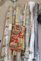 Multiple fabric rolls wrapped in plastic with visible Calico branding and hanging toile remnant