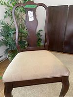 Front view of chair showing wood frame and upholstered seat