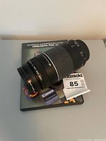 Lens with both caps placed on top of the instructional DVD
