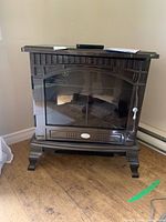 Front view of bronze Dimplex electric stove heater on floor