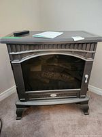 Front view of Dimplex stove with remote and manual on top
