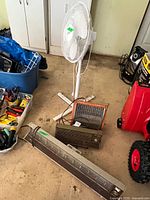 Group shot of all appliances: pedestal fan, GE heater, Airking unit, Kenmore heater(s)