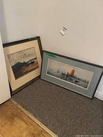 Both framed prints leaning against wall