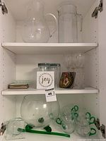cabinet view showing full lot: punch bowl with cups, green ladle, pitchers, tumblers, wine glasses, tiles, coasters