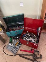 Overview of two toolboxes, corded drill, socket set and pipe wrenches