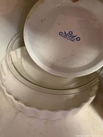 White ceramic fluted pie dish, clear glass pie dish, white plate with blue floral motif