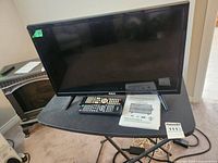 RCA 24-inch LED TV/DVD combo with remote and manual on table