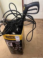 Pressure washer partially in box with cords and gun handle visible