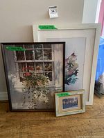 All three framed artworks leaning against wall