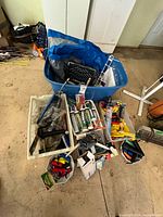 Overview of blue tote with bins of tools, sealant tubes, flashlights and accessories