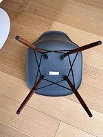 Underside view showing medium gray shell, walnut legs, black wire base