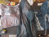 All three hoodies laid out: packaged black/red, dark green Celtic, blue/white Celtic