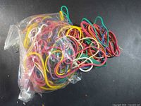 Bag of assorted-colour rubber bands, contents visible