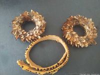 Two feather rosettes and feather hatband on table
