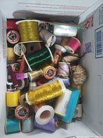 Top view of open box showing assorted thread spools
